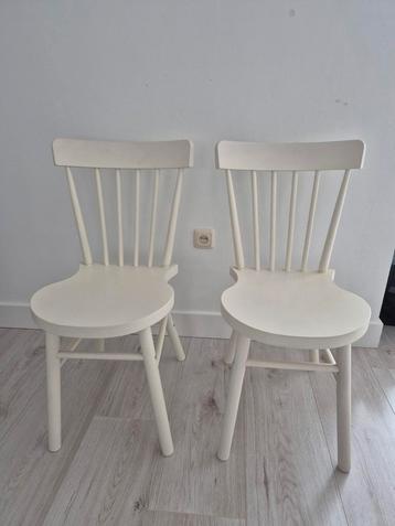 Twee witte houten stoelen beschikbaar voor biedingen