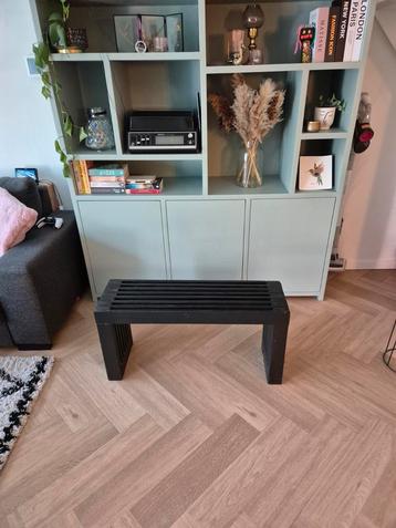 Zwart houten bankje beschikbaar voor biedingen