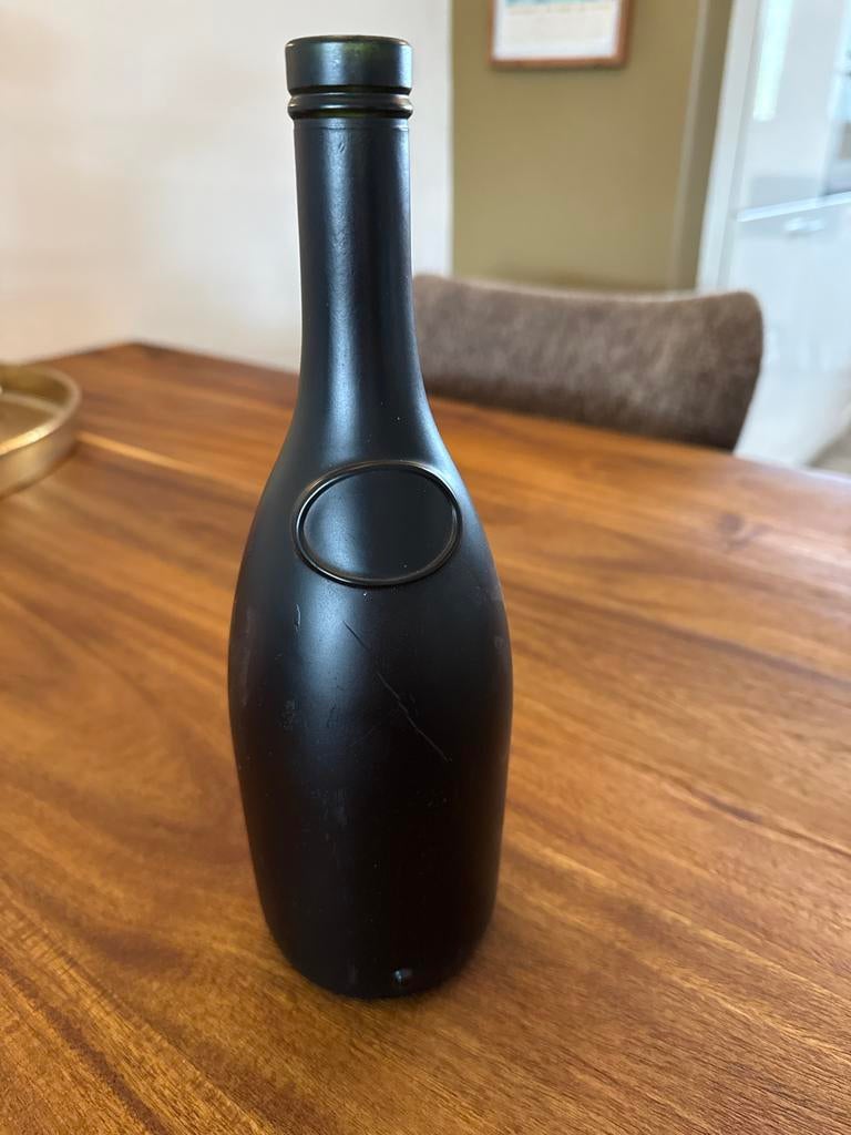 Zwarte glazen fles met reliëf, Ophalen