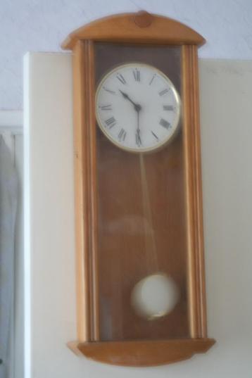 Mooie wandklok met bewegendeslinger beschikbaar voor biedingen